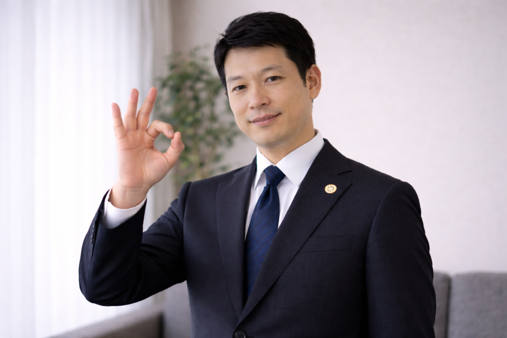 弁護士がOKサインをしている様子
